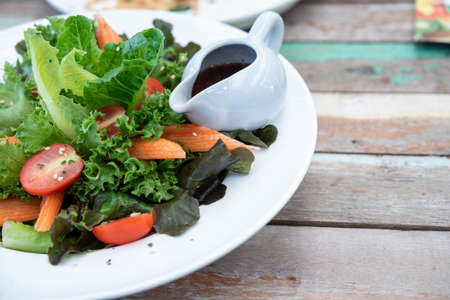 Salad with cheese and fresh vegetables isolated on white background. Greek salad on wooden floors. Healthy side dishes. Photosの写真素材