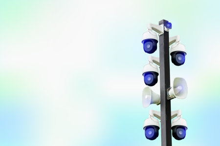 Cctv with loudspeaker broadcasting on a steel column on colored