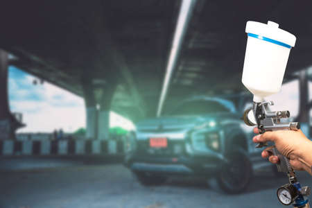 Blurred background paint sprayImage of the painter's arm hand holding industrial size spray gun used for industrial painting and coating and isolated on white background clipingpartの写真素材