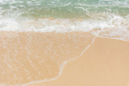 Sea waves bubbles on the sandy beach