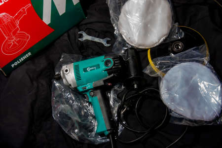 A close-up of a cordless drill and a set of spare parts.
