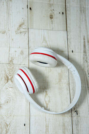 wireless headphones red white on wooden floorの写真素材