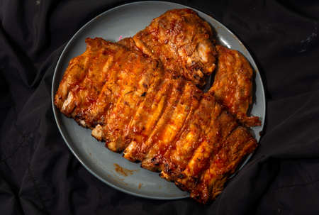 Baked pork ribs in a plate. on a dark backgroundの写真素材
