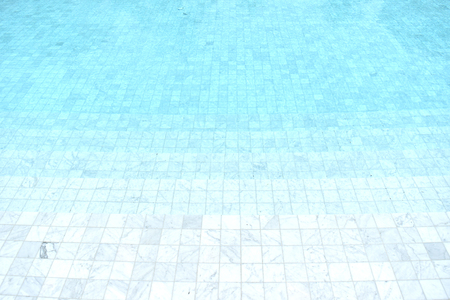 Background of a blue tiled pool with clear cool rippling waterの写真素材