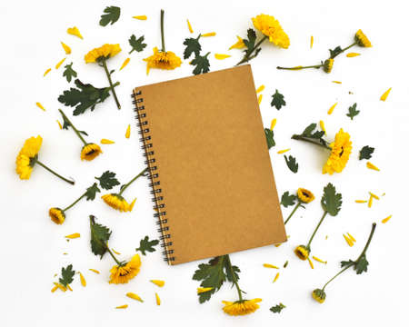 Framework from yellow flowers on white background. Flat lay composition with notebookの写真素材