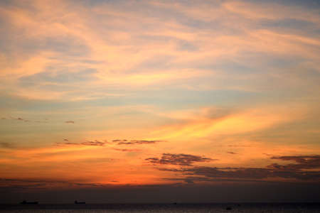 Dramatic sunset. Orange-violet sky. The sun behind the clouds. Landscape.の写真素材