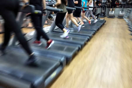 Blurred healthy cardio running people burnout fat on runway at fitness gymの写真素材