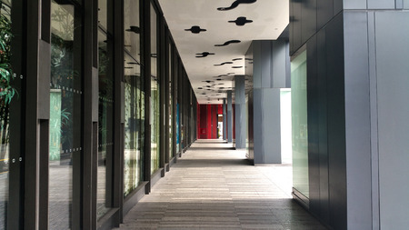 Empty corridor with sun shines on the large glass panels on the side