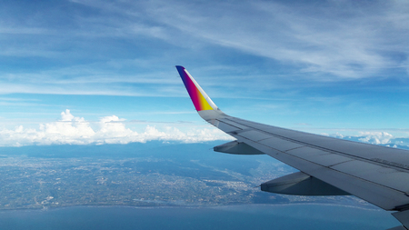 Airplane wing from inside, cloudy skyの写真素材