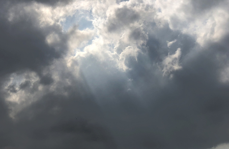 Sun rays shine through heavy dark cloud