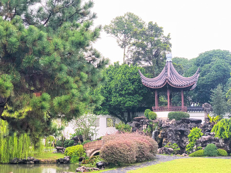 Japanese style pavilion elevated in the park with greeny background on a cloudy skyの写真素材