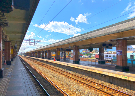 Empty train railway platform without shelter on a cloudy dayの写真素材