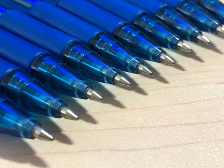 Blue ball pens on a wooden texture backgroundの写真素材