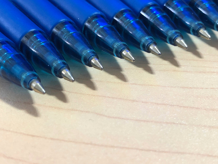Blue ball pens on a wooden texture backgroundの写真素材