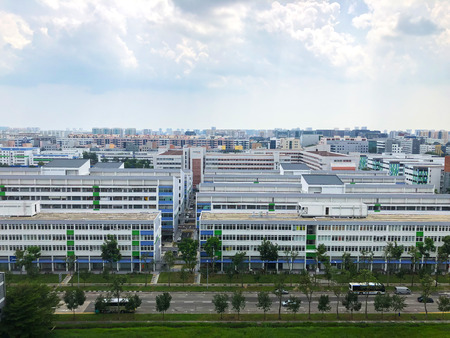 Pretty panoramic view of cloudy sky with industrial building and road with little traffic, garden...