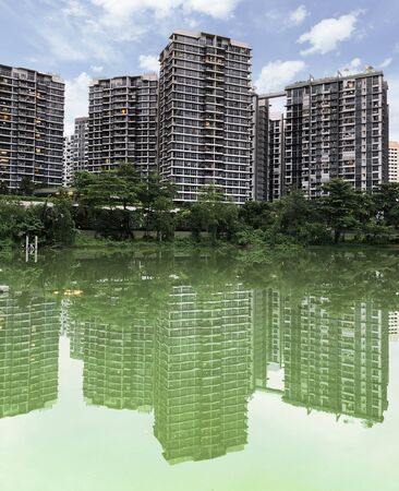 Reflection of residential apartment blocks by the riverの写真素材