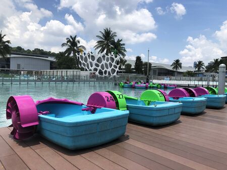 Colorful paddle boat parked at the deck beside the water