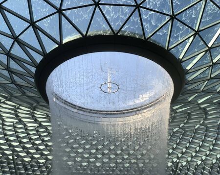 Singapore: 13 April 2019 - Waterfall at Jewel Changi Airport, Singapore. Named the Rain Vortex, it is the tallest indoor waterfall, which is surrounded by a terraced forest setting.の写真素材