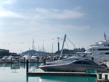 Luxury yachts docked in the port under cloudy sky. Motor boats moored at pier in blue water.の写真素材