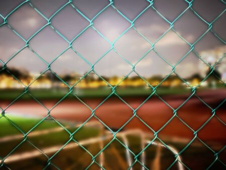 Chain link fence with blurred stadium as background