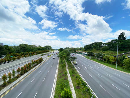Street view with two way traffic around nature park from overhead pedestrian bridgesの写真素材