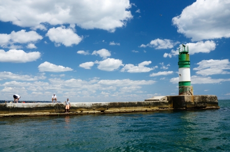 Illichivsk,Ukraine,July 21,2013- people fishing at lighthouse of sea port in Illichivsk ,Ukraine のeditorial素材