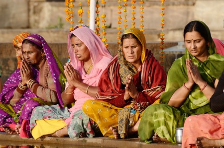 Pushkar,India,November 12,2013 - senior women perform puja - ritual ceremony at holy Pushkar Sarovar lake, India Pushkar -one of seven sacred cities in Indiaのeditorial素材