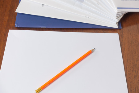 Pencil and paperwork with reports arranged on wood table.の写真素材