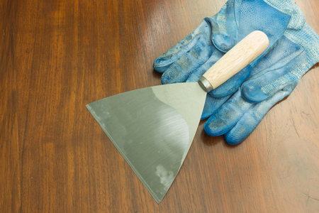 paint scraper with wood handle and working gloves.の写真素材