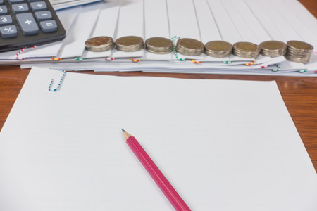 pencil reports arranged and document place with paperclip have calculator and Coin on wooden floor.の写真素材
