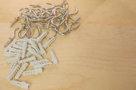 Screw hooks and plastic anchors on the wood background.の写真素材