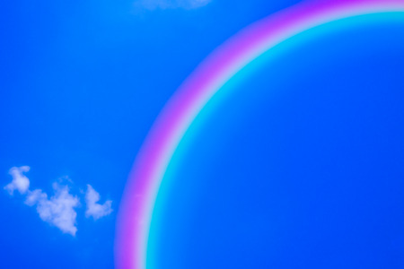 beautiful rainbow on blue sky background with cloudsの写真素材