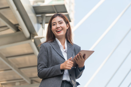 Businesswoman holding tablets and laughing happily.の写真素材