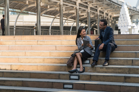 Businessman sitting on the stairs talking on the town.Right corner of the imageの写真素材