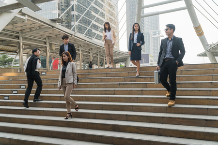 Businessmen are walking up and down the stairs to work in the morning.の写真素材
