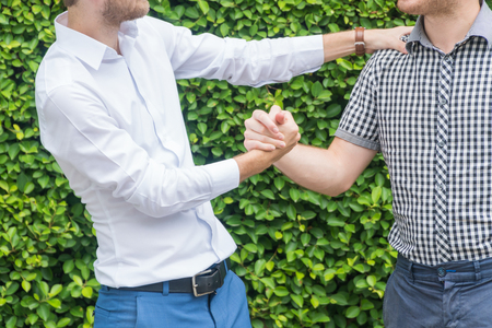 Friendship concept Hands of young friends shake hands on tree background.の写真素材