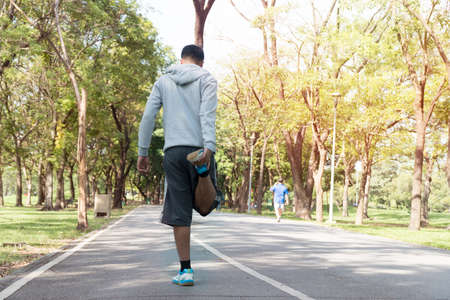 The back of young man sportswear doing stretching exercise relaxing and warm up after jogging and...