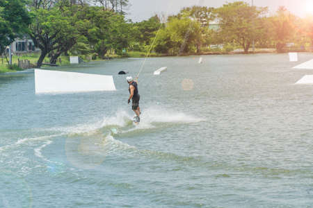Handsome man wake boarding on a lake with cable in Thailandのeditorial素材