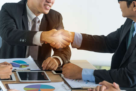 Businessmen shaking hands in a meeting together.Concept Success