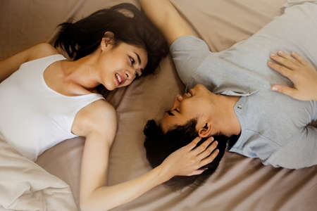 Top view of romantic young couple lying in the bed.