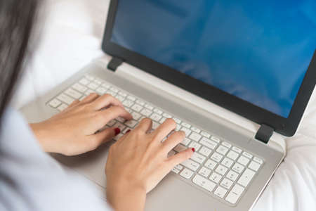 Focus on the hand of beautiful young woman using computer keyboard.の写真素材