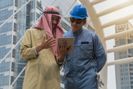 Arab businessman and construction engineer looking tablet while working in the city.の写真素材