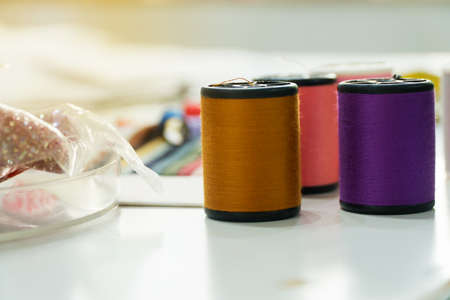Close up The thread tube On the desk of fashion designer with various accessories.