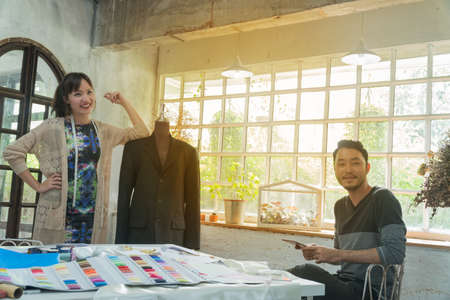 Two Asian young fashion designer on front of the table at studio.の写真素材