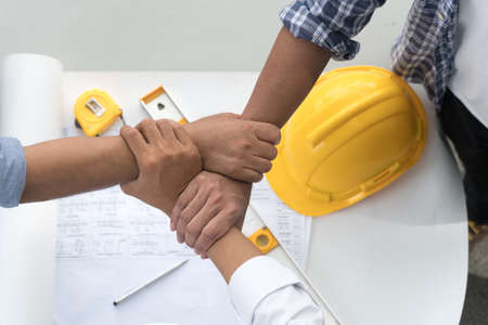 Top view engineering contractor joining hands with architect after finish meeting about develop a...