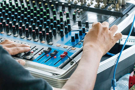 Hands of man controlling the console of a large hi-fi system. Sound equipment at outdoor.の写真素材