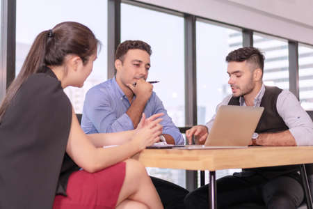 Group businesspeople colleagues talking about planning project in the workplace. Man holding pen...