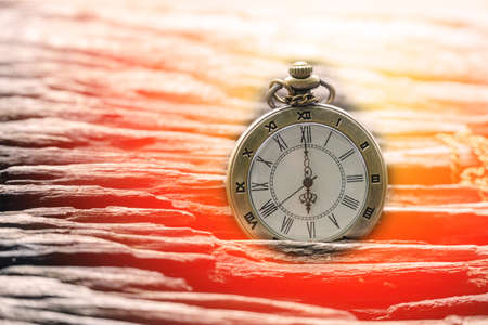 Vintage old pocket clock showing time on the wooden board.の写真素材