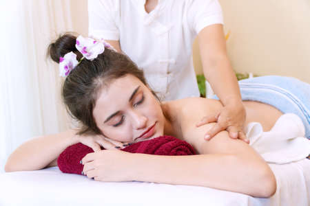 Close up of young woman wear towel relaxation for body and head massage spa treatment back while lying on the bed at spa salon. Spa and massage conceptの写真素材