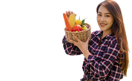 Healthy young woman with fresh organic vegetable in basket while looking at camera  isolated on white background. Lifestyle vegetarian concept.の写真素材